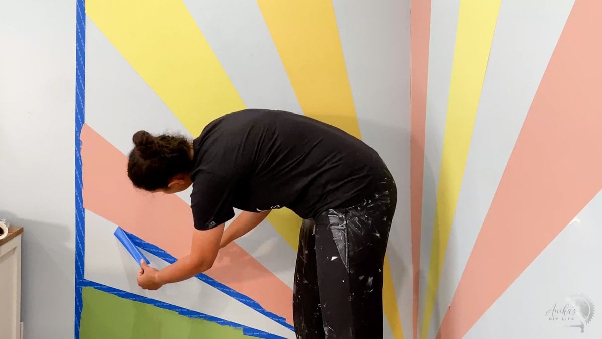 Woman peeling tape from wall