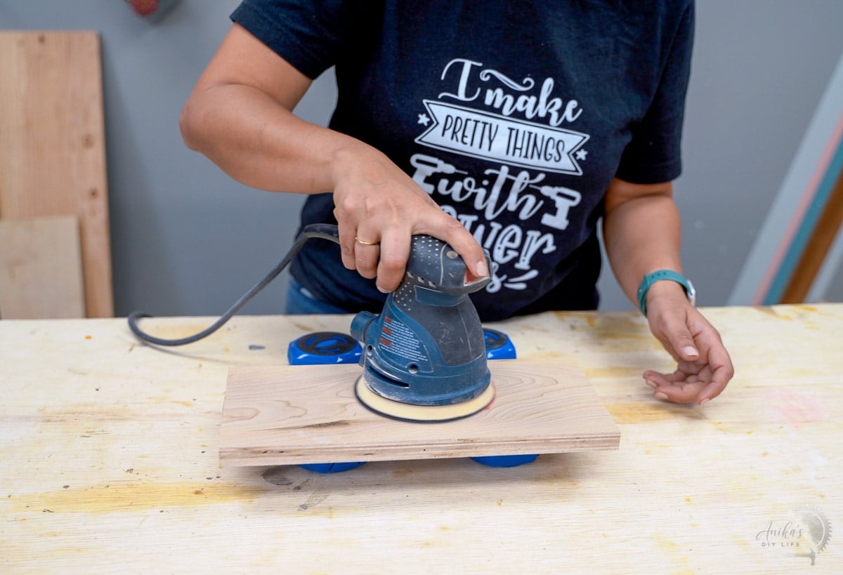 Woman sanding a board resting on multipurpose project blocks.