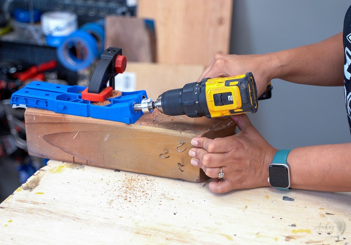Woman making pocket hole using the XL pocket hole jig on a scrap 4x4 board