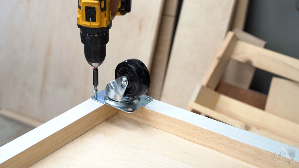 attaching swivel casters to the bottom of the shelf