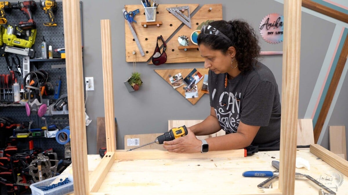woman attaching 2x2 boards with pocket hole screws in a workshop.