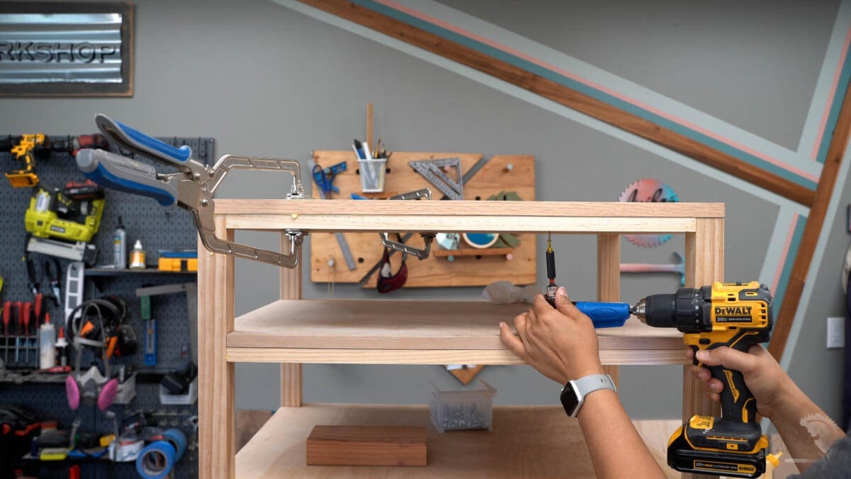 Woman countersinking screw into the top with the help of a right angle driver.