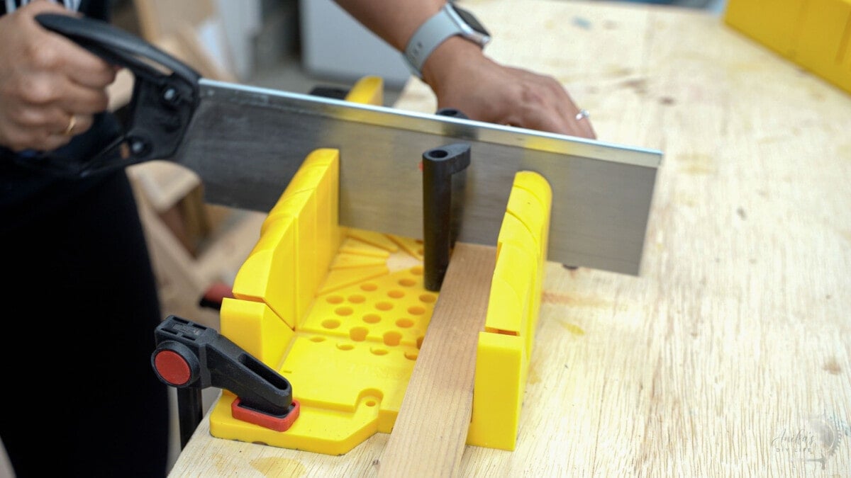 making a cut at 0 degrees using a miter box on workbench