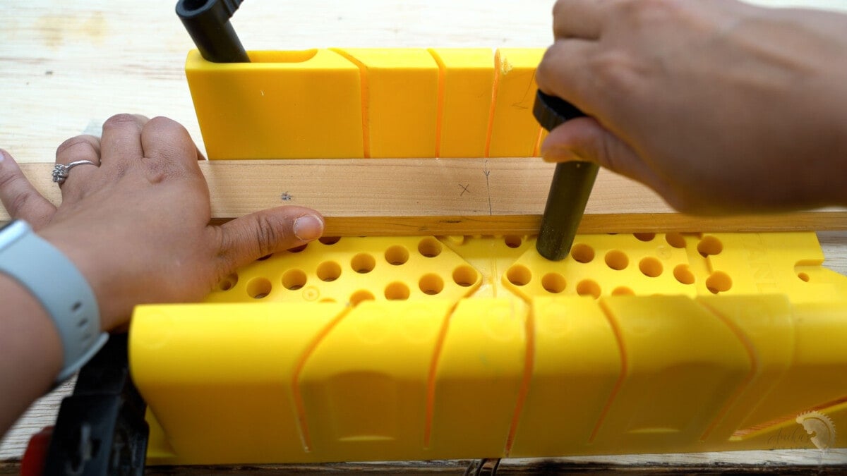 securing the board with cam pins into a miter box.