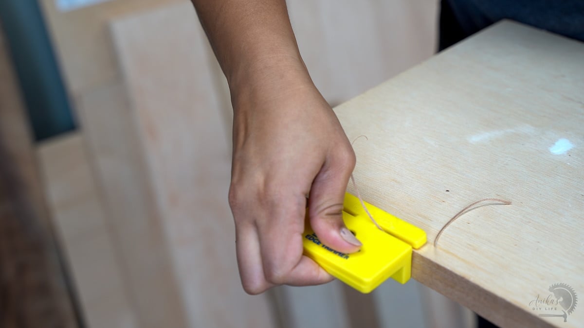 woman trimming off excess edge banding using a trimming tool