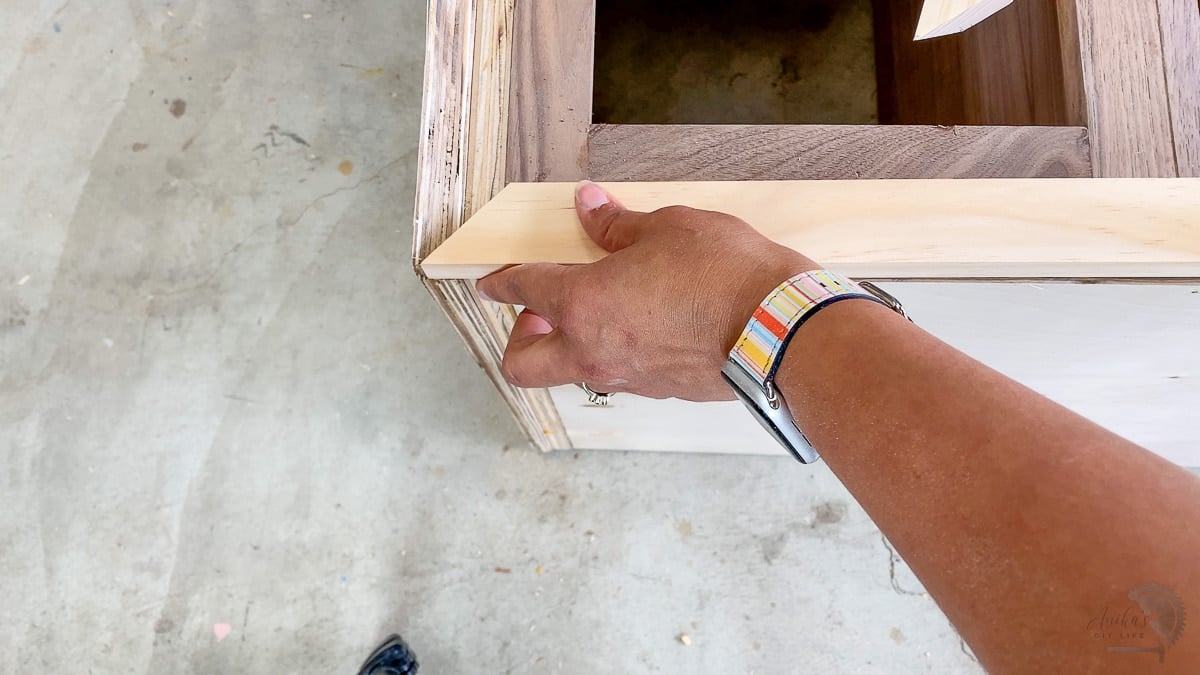 Woman covering plywood edges with a 1x2 board