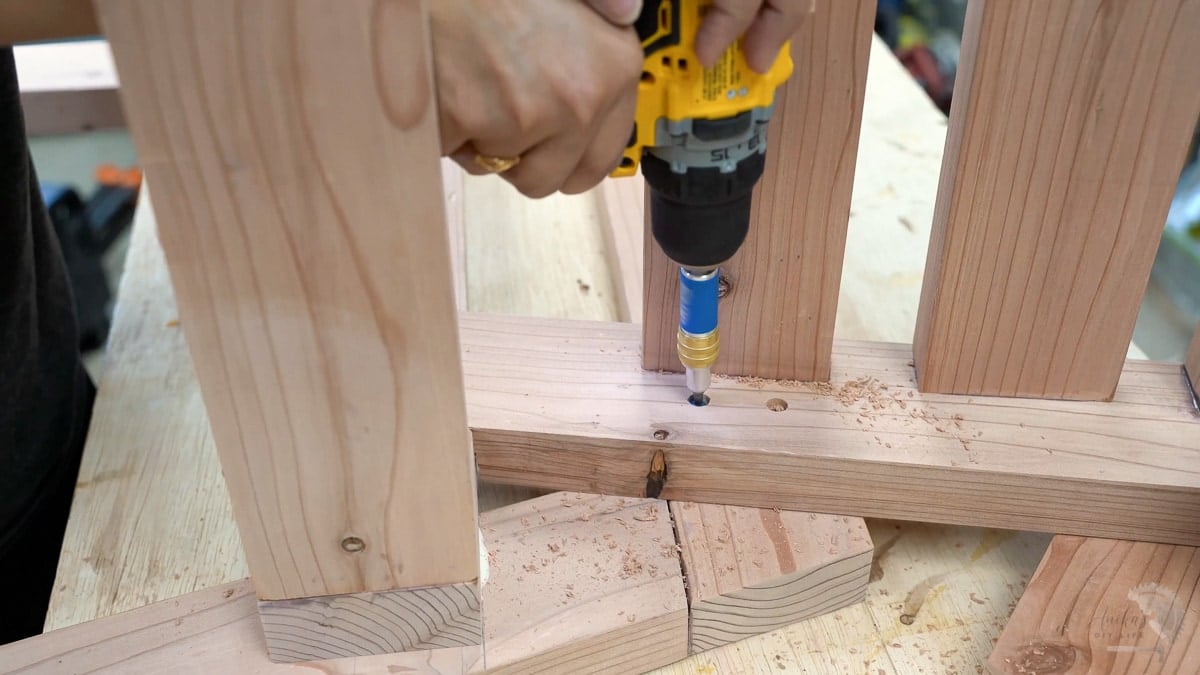 Woman adding countersunk screws to attach the chair to sides