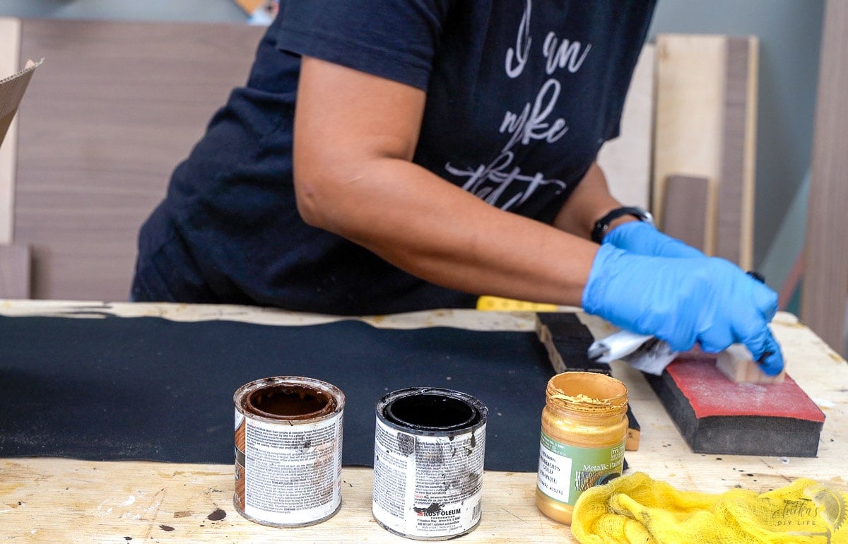 cleaning up pieces of scrap wood with a sanding block