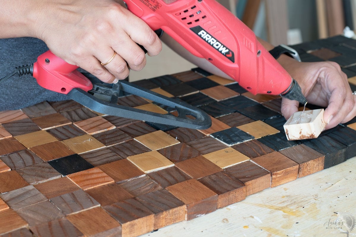 Applying hot glue to another block