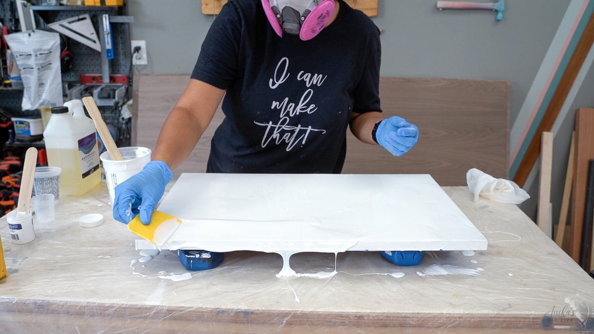 Spreading epoxy on plywood board to smooth it out