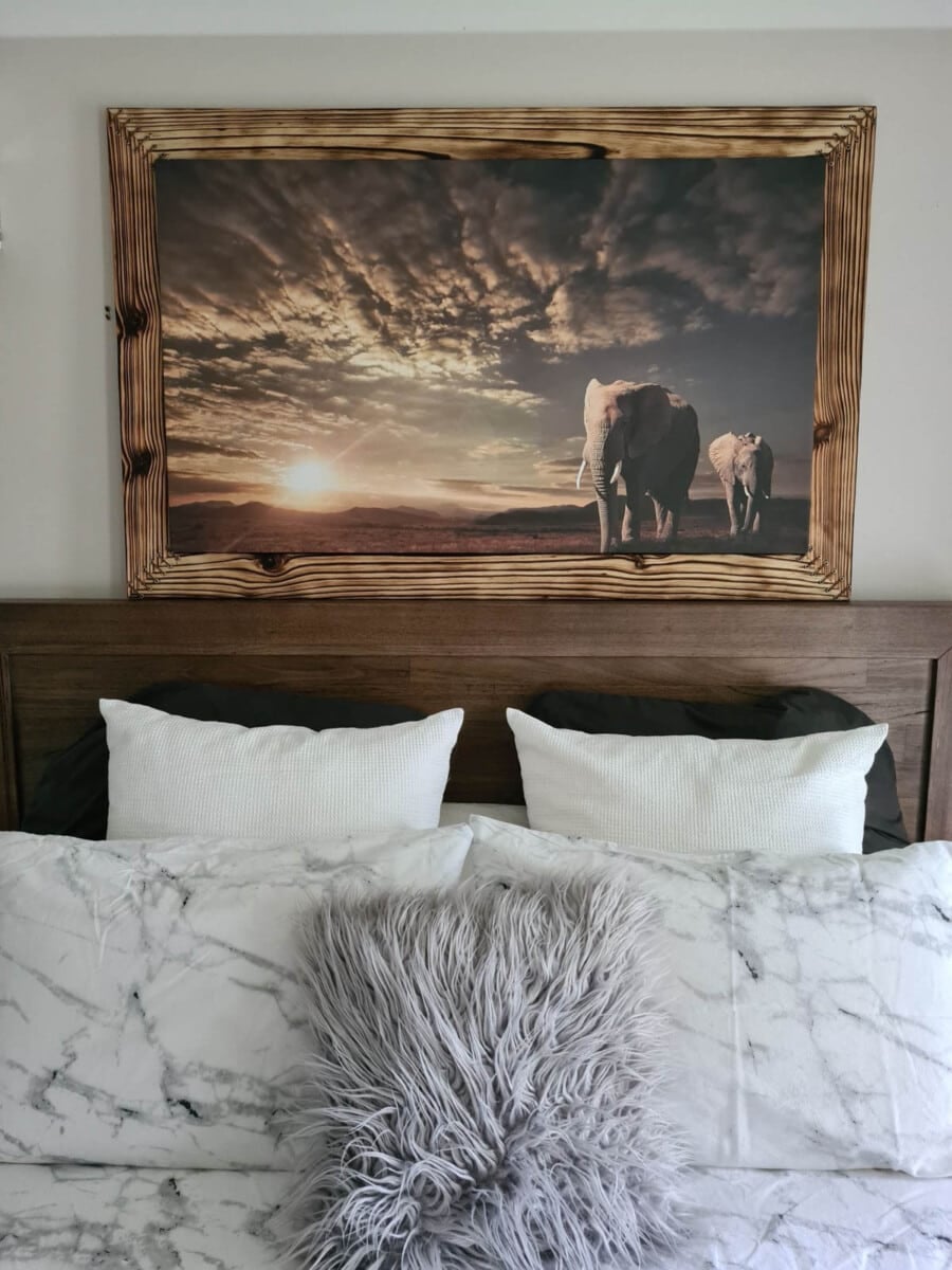 Wood burned picture frame sitting on top of headboard