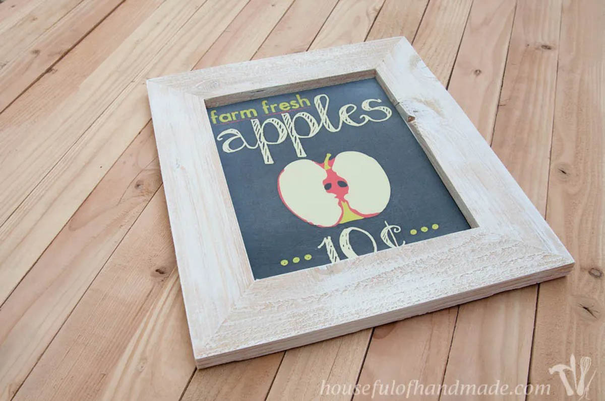 DIY picture frame laying on a table with apple sign graphic in it