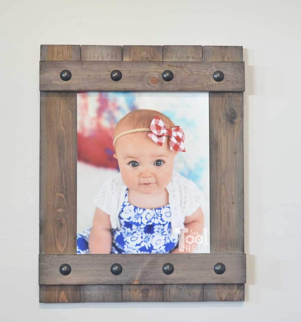 Wood picture frame with metal rivets
