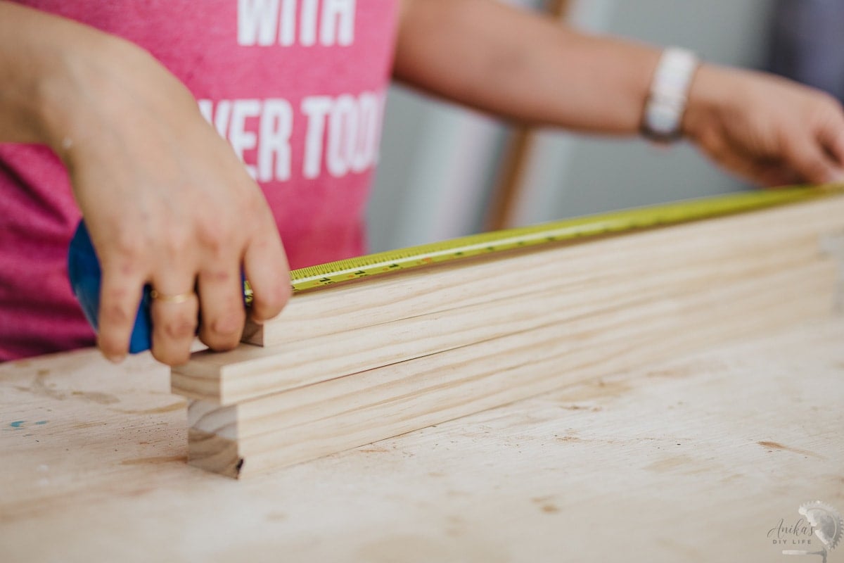 woman measuring board with measuring tape