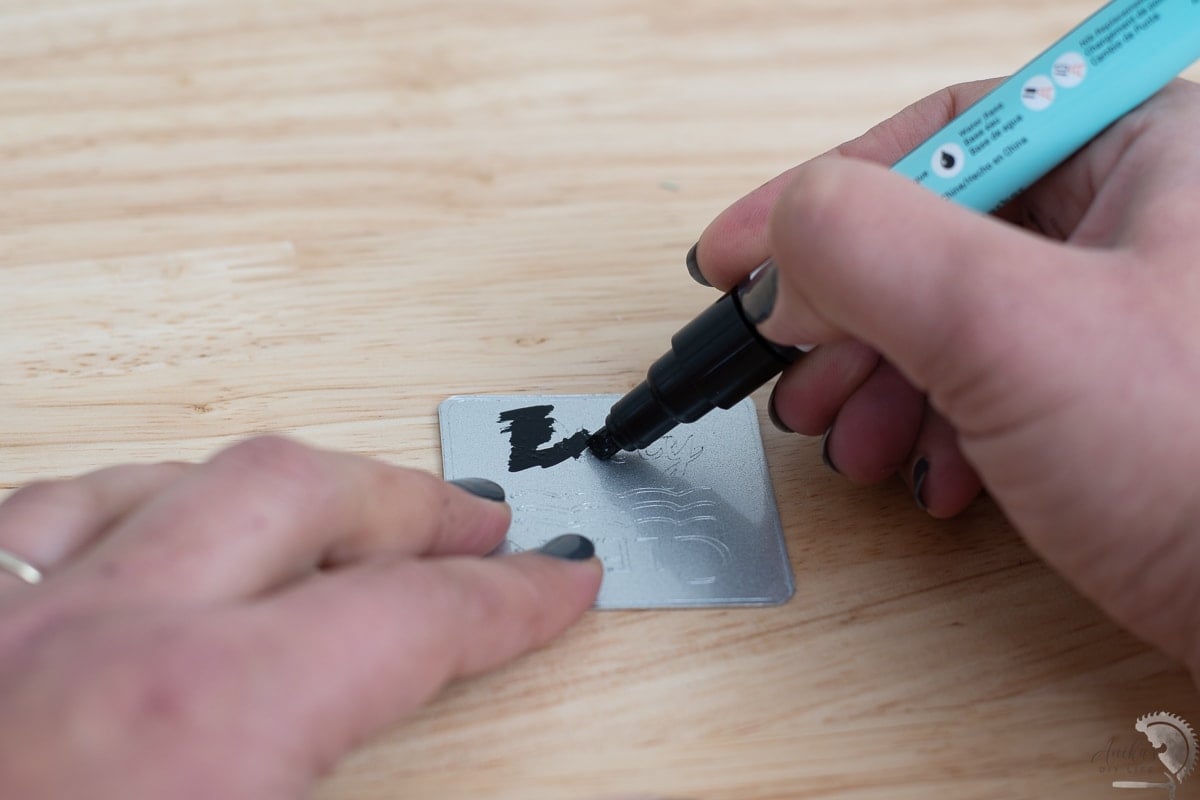 rubbing the enamel marker over the engraved areas