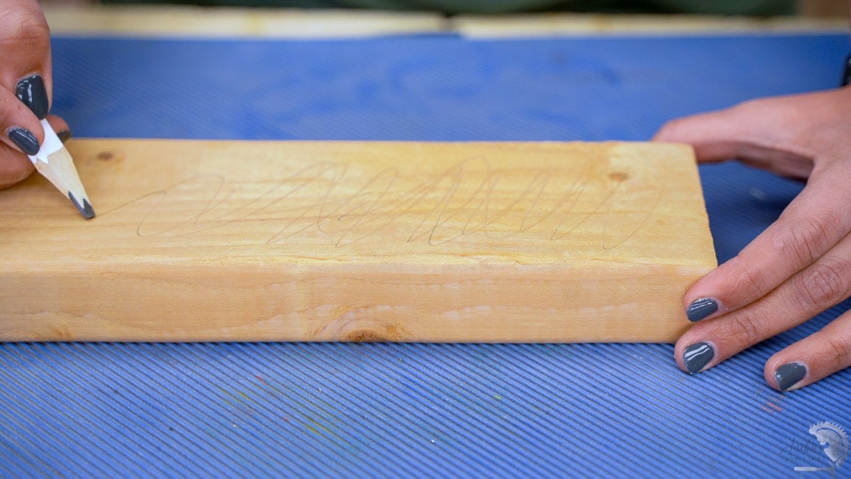 Making a pencil line on the wood to start sanding