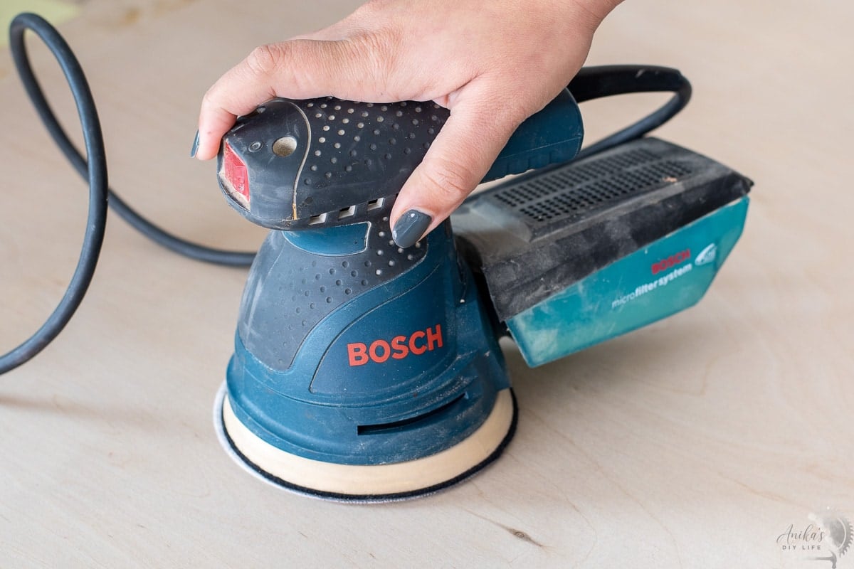 woman holding a random orbital sander