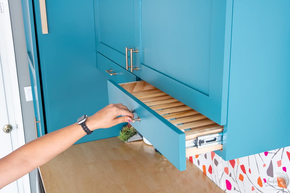 woman pulling out the drying rack from the cabinet