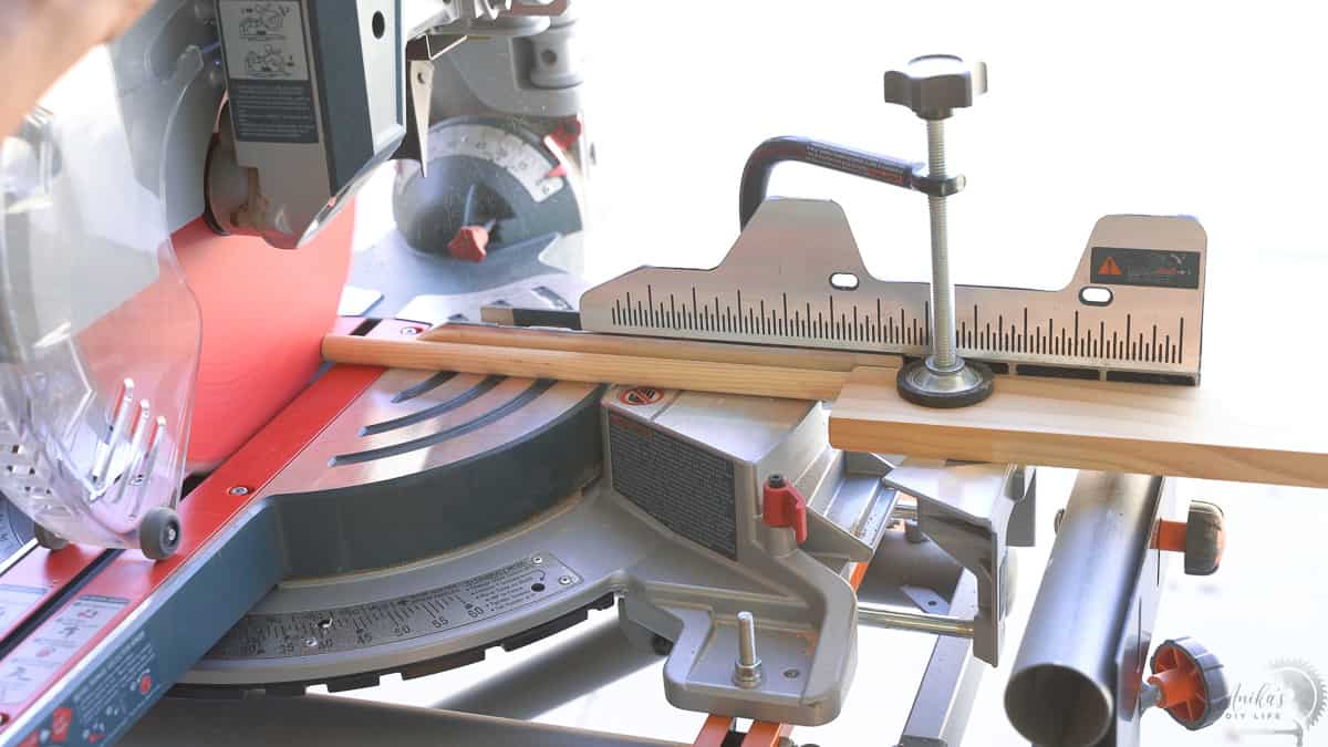 Woman cutting dowels on the miter saw with a stop block.
