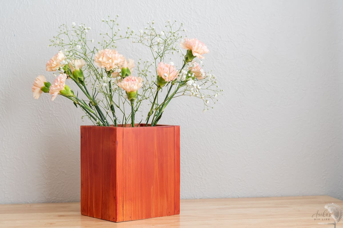 redwood vase on a desk with flowers