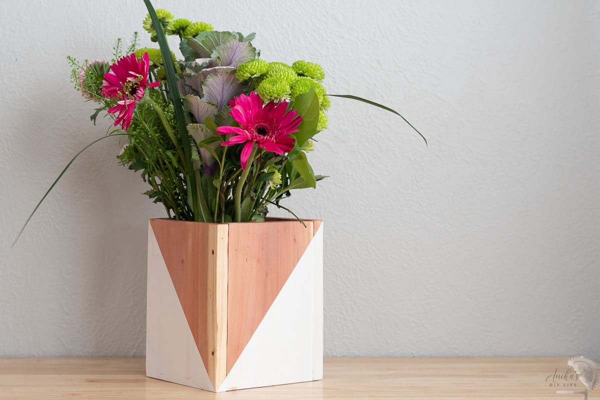 white and natural redwood vase on table with flowers