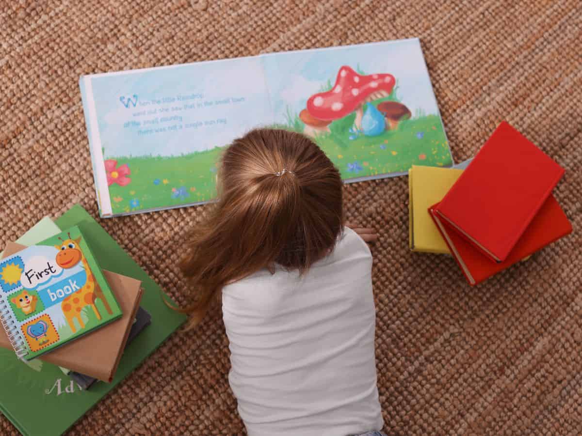 little girl reading books from subscription box