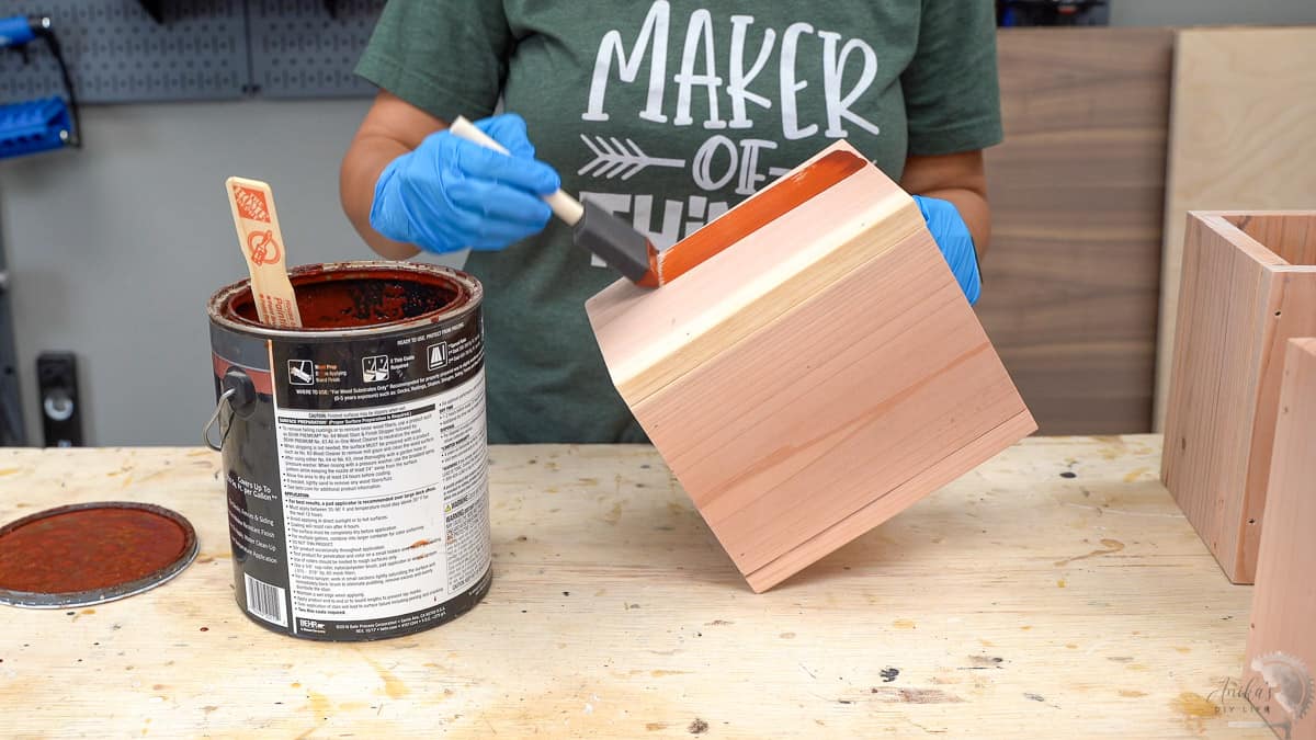 woman staining the DIY wood vases and planters