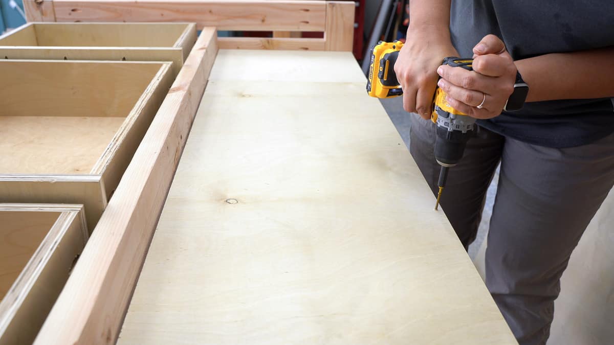 Woman attaching the screws into the shelf