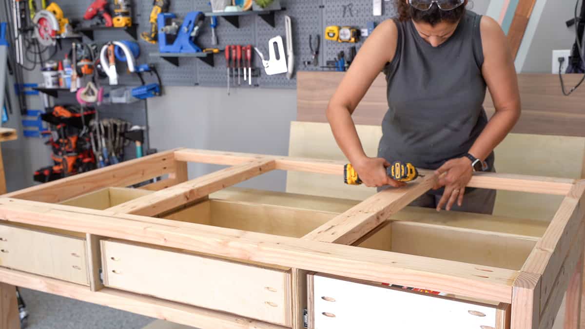 Woman building the top frame of the workbench