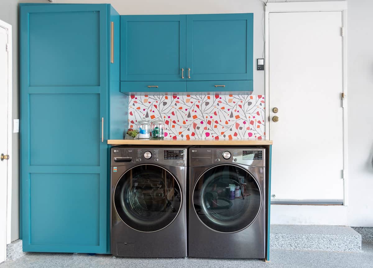 Blue laundry room in garage with colorful backsplash