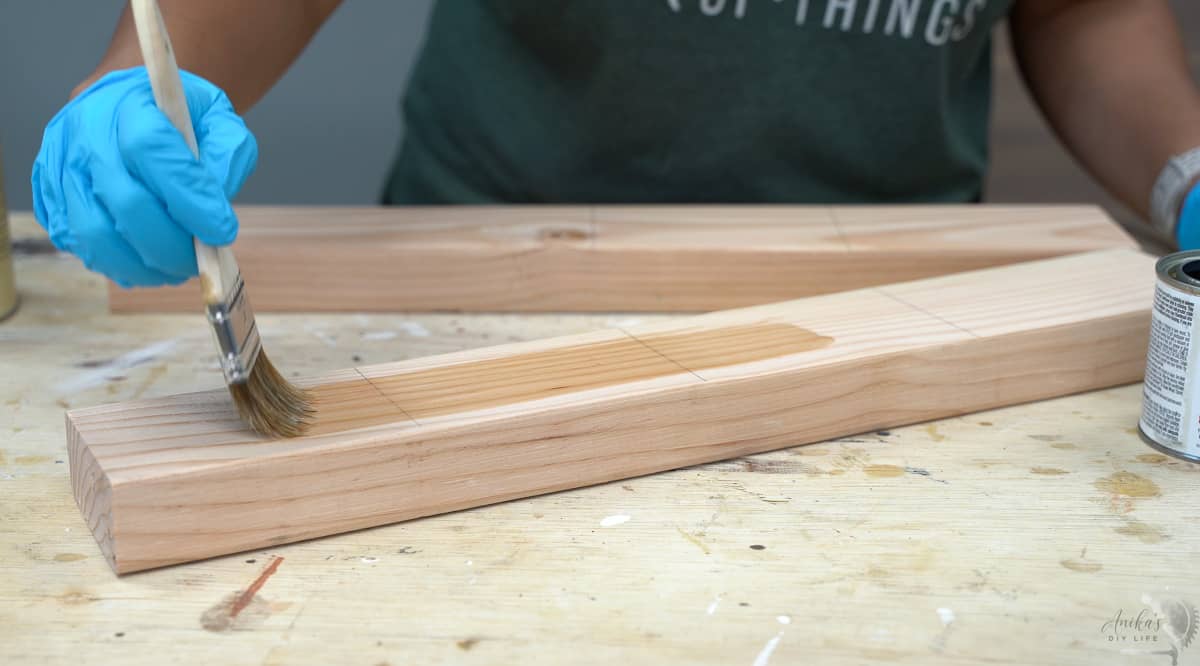Applying pre-stain wood conditioner to the 2x4 board