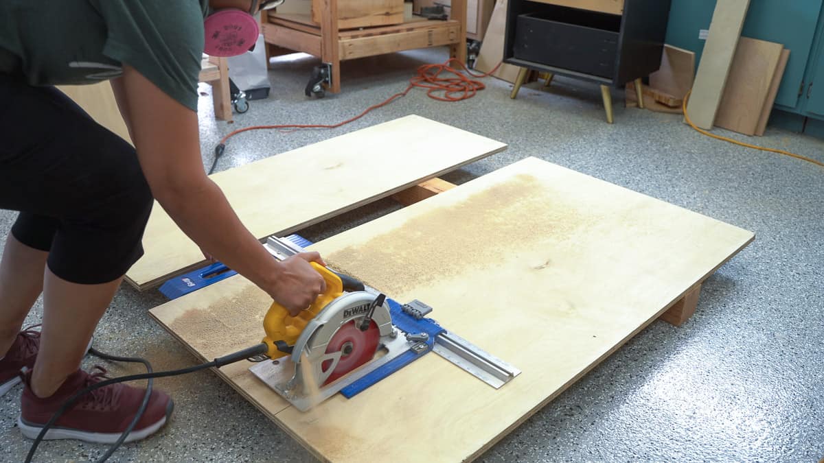 Woman cutting plywood using a circular saw a Kreg Ripcut