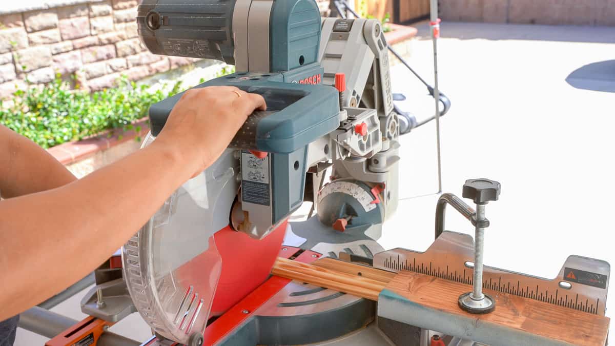 Woman cutting molding on a miter saw
