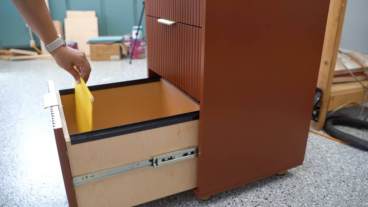 Woman adding files to a diy file cabinet drawer