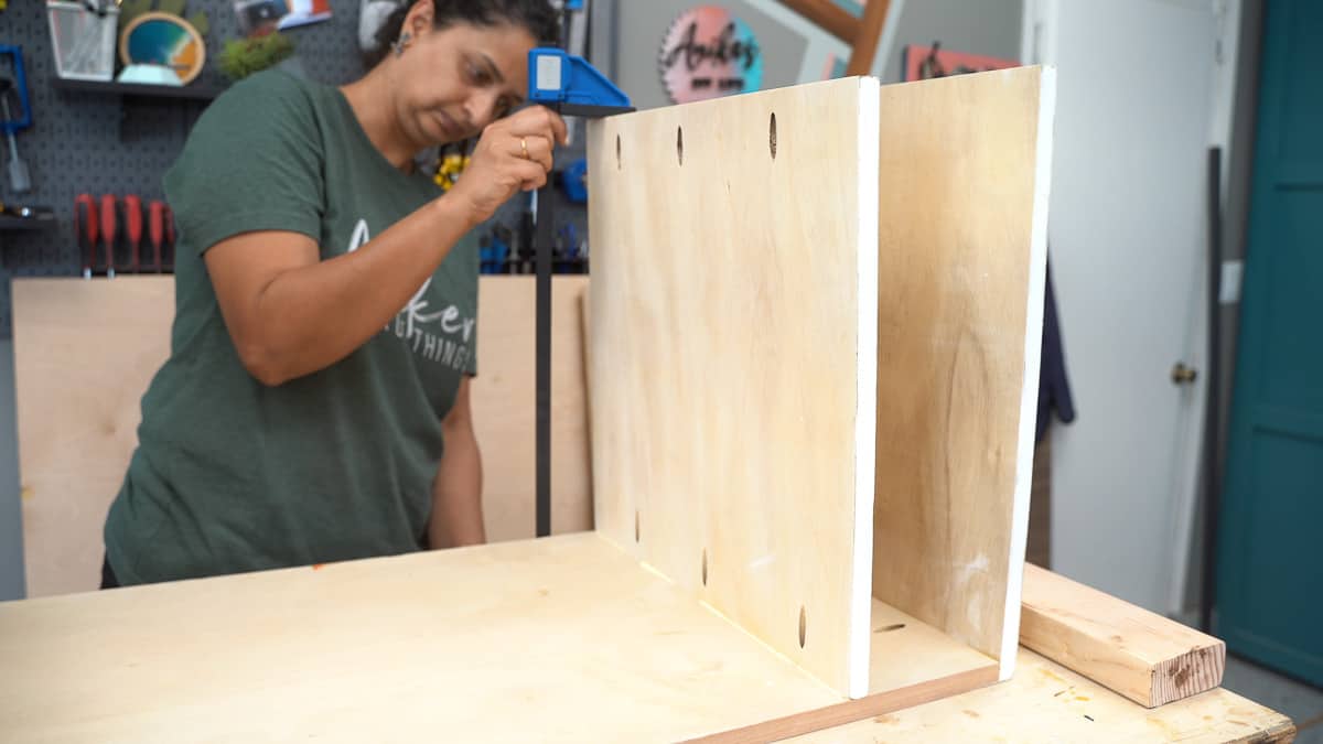 Woman attaching boards to build a wood file cabinet