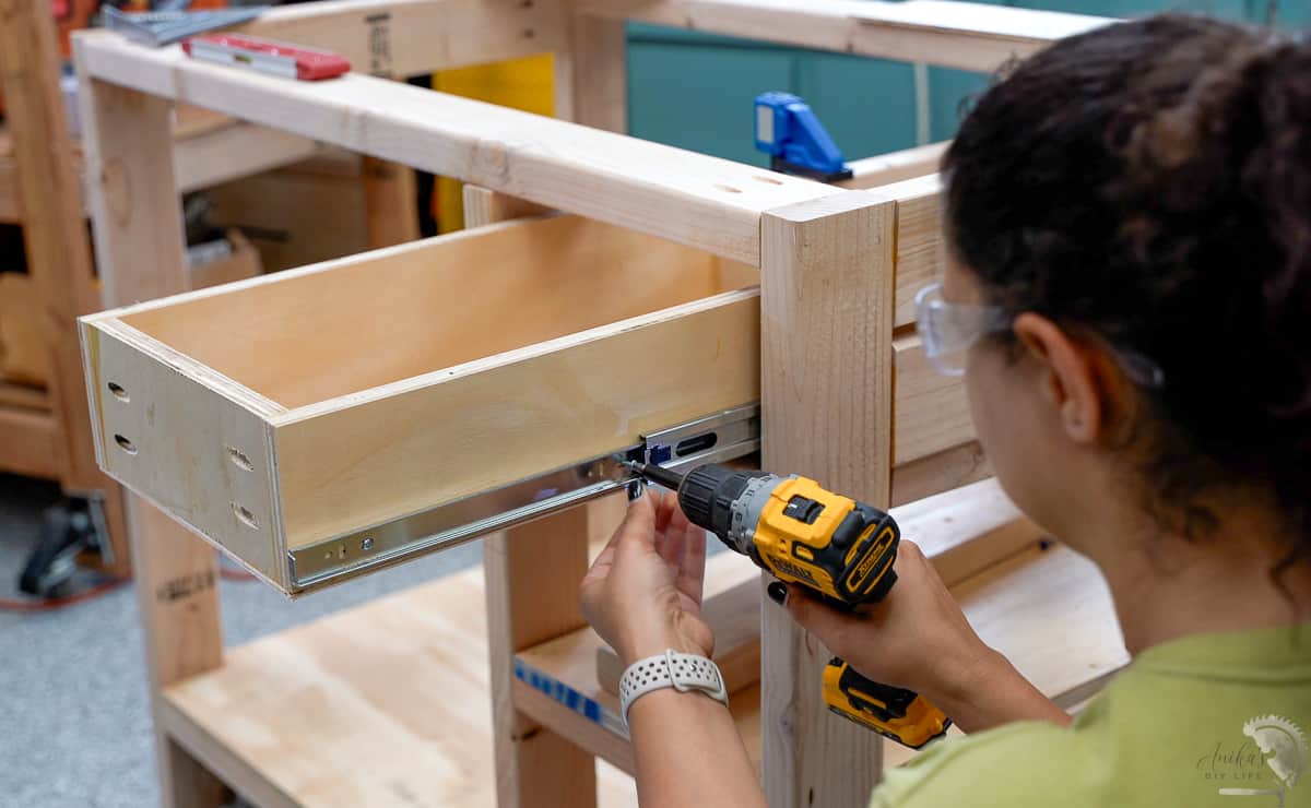 Woman attaching drawer slide to drawer