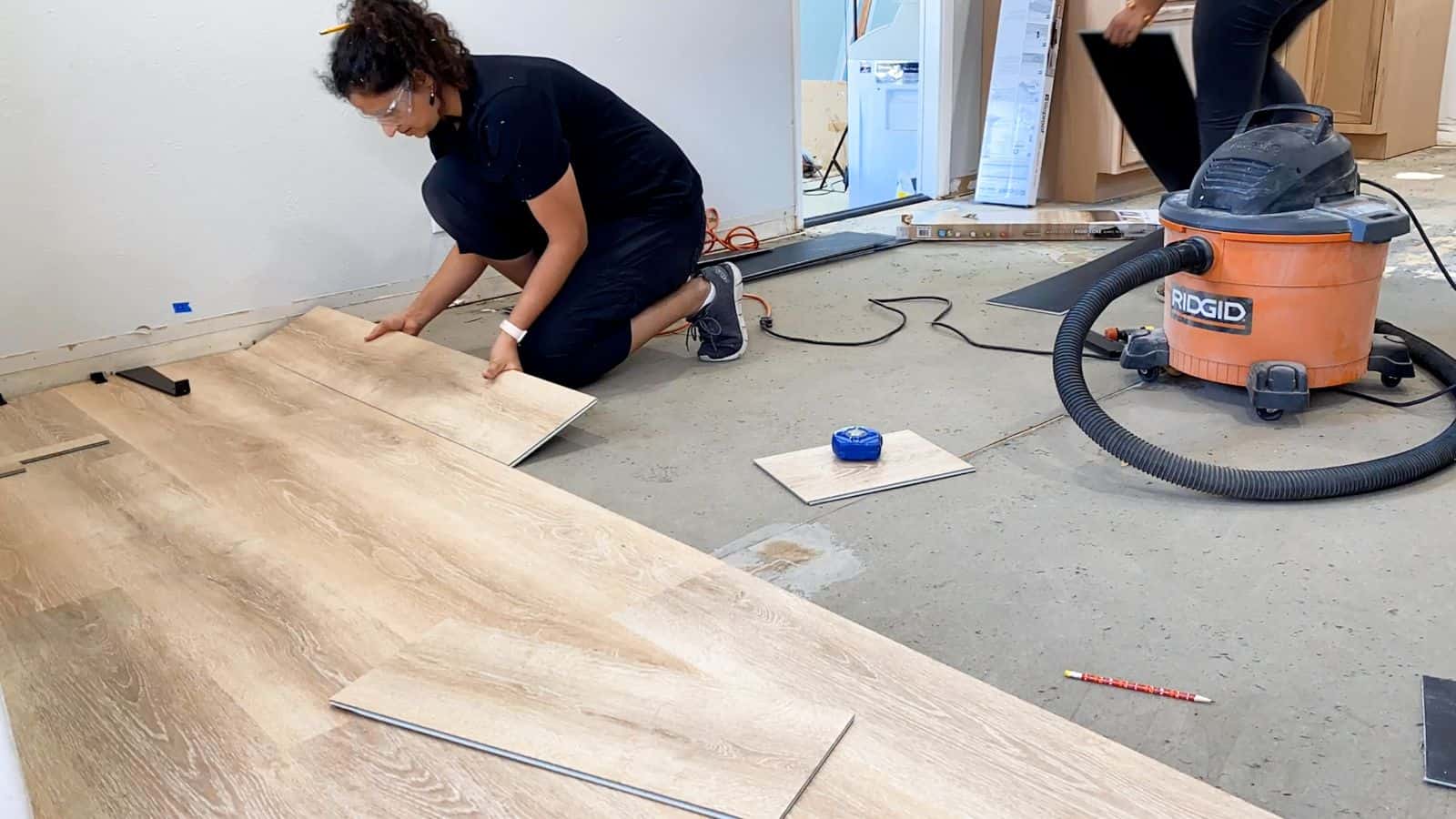 Anika installing flooring in kitchen