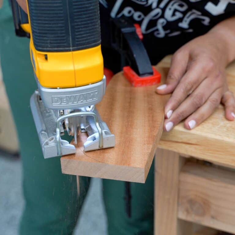Anika cutting a board using a jigsaw
