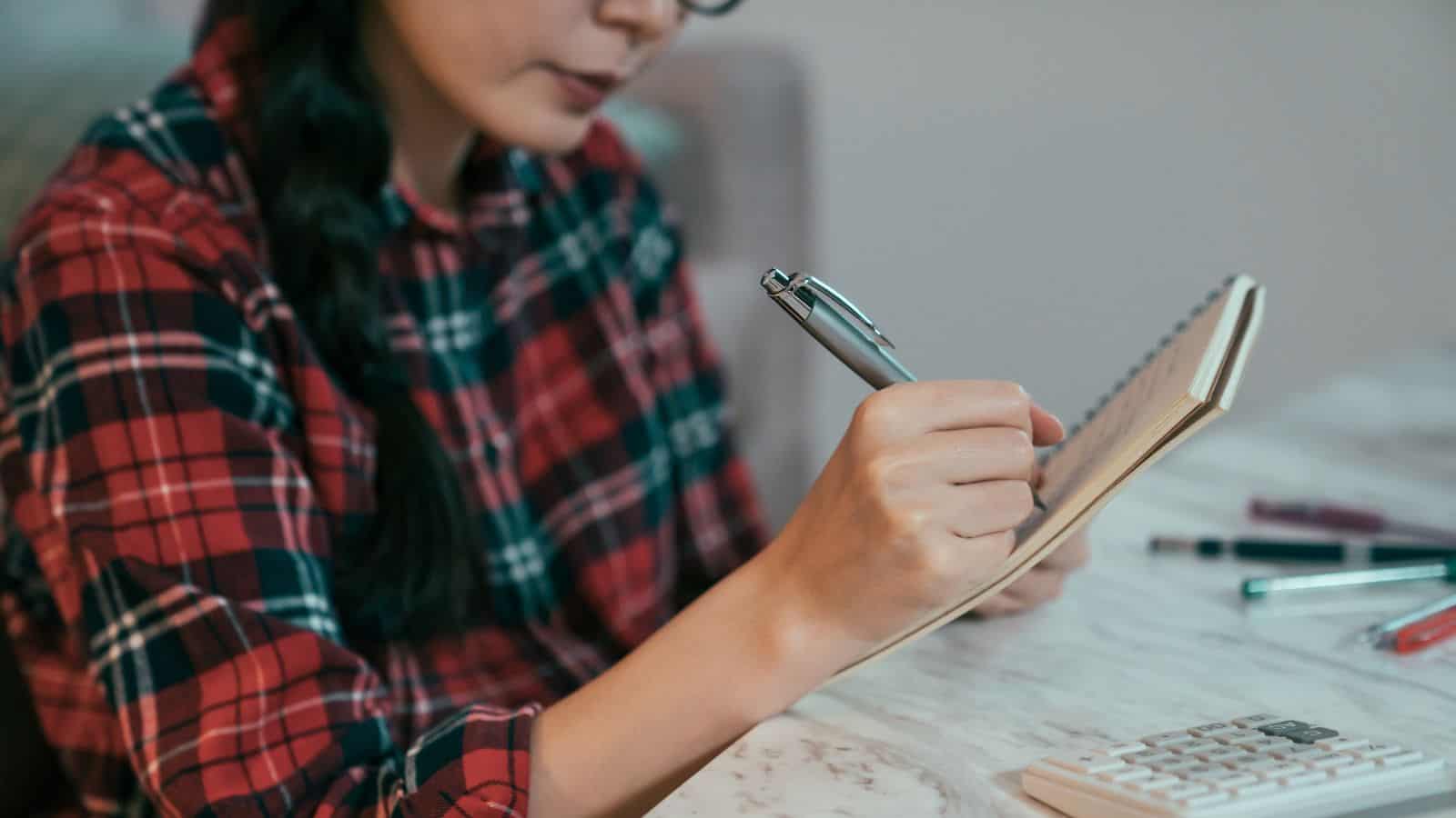 woman in plaid shirt making a budget