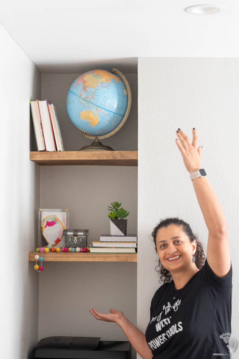 Anika next to floating shelves in nook