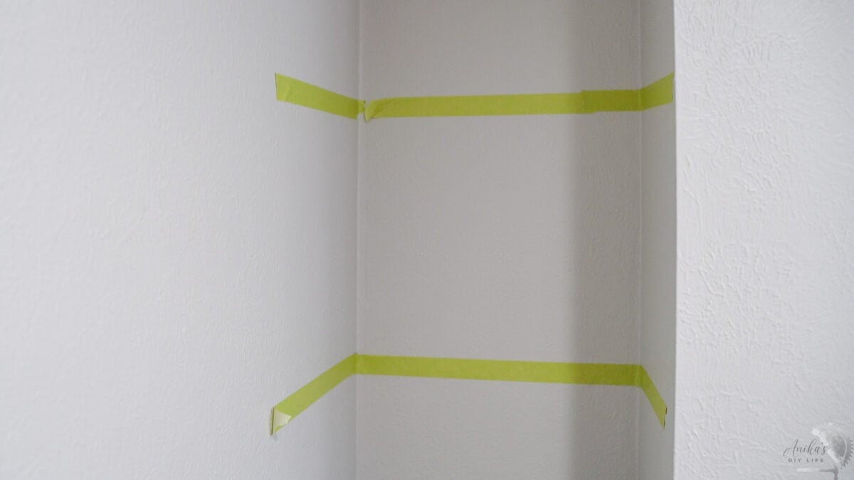tape to show location of the floating shelves in a nook