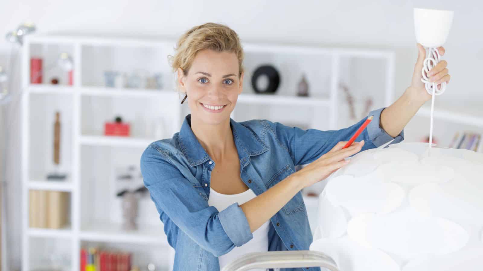 woman changing a light fixture