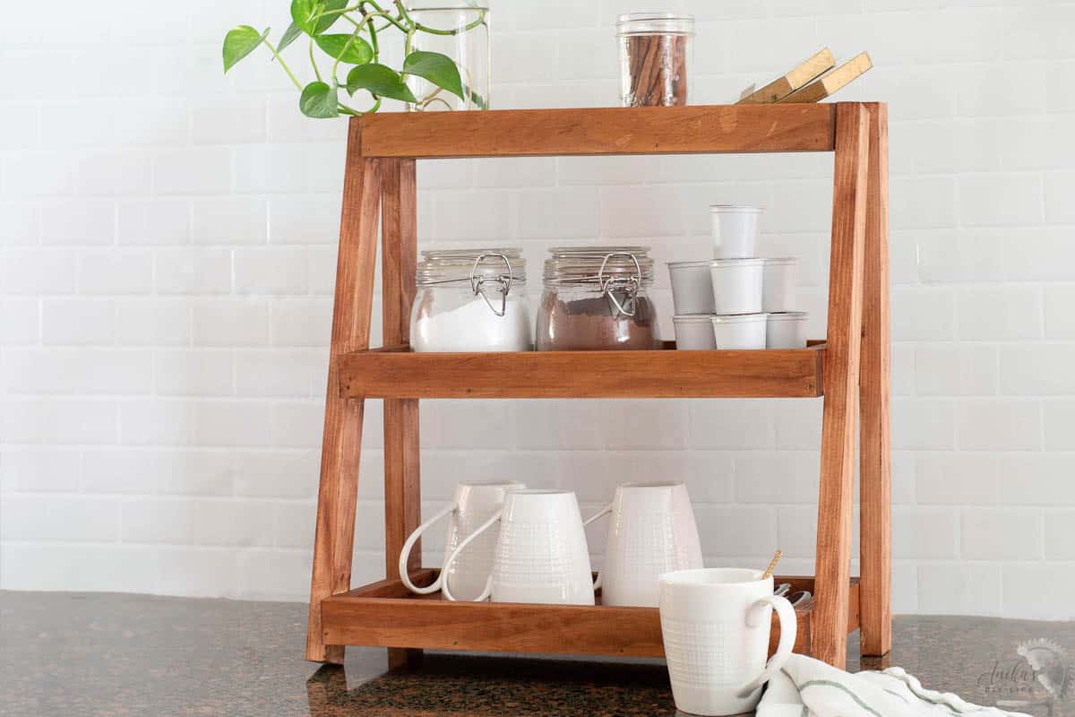 Wood tiered organizer with coffee and tea supplies in kitchen