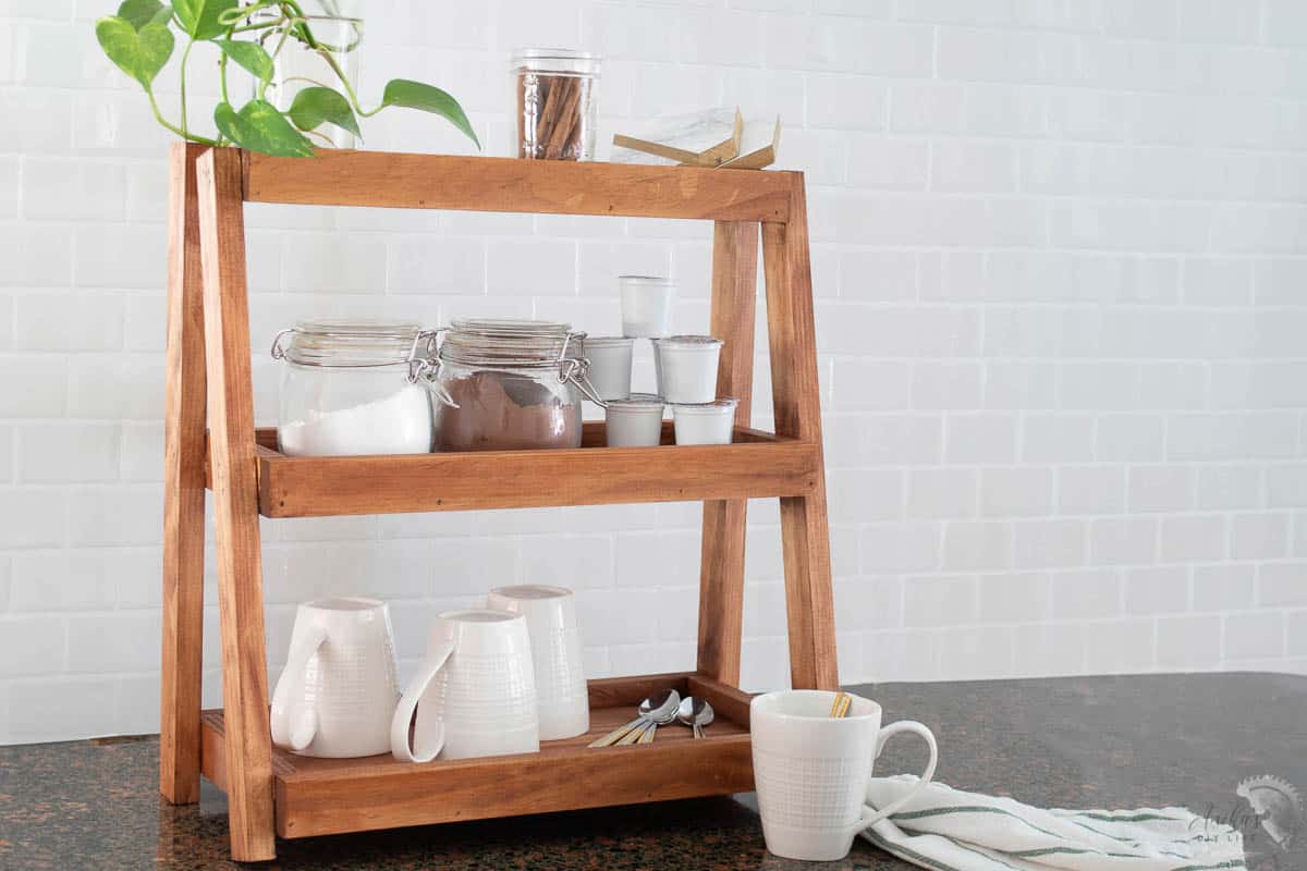 wooden tiered organizer in kitchen with tea and coffee supplies