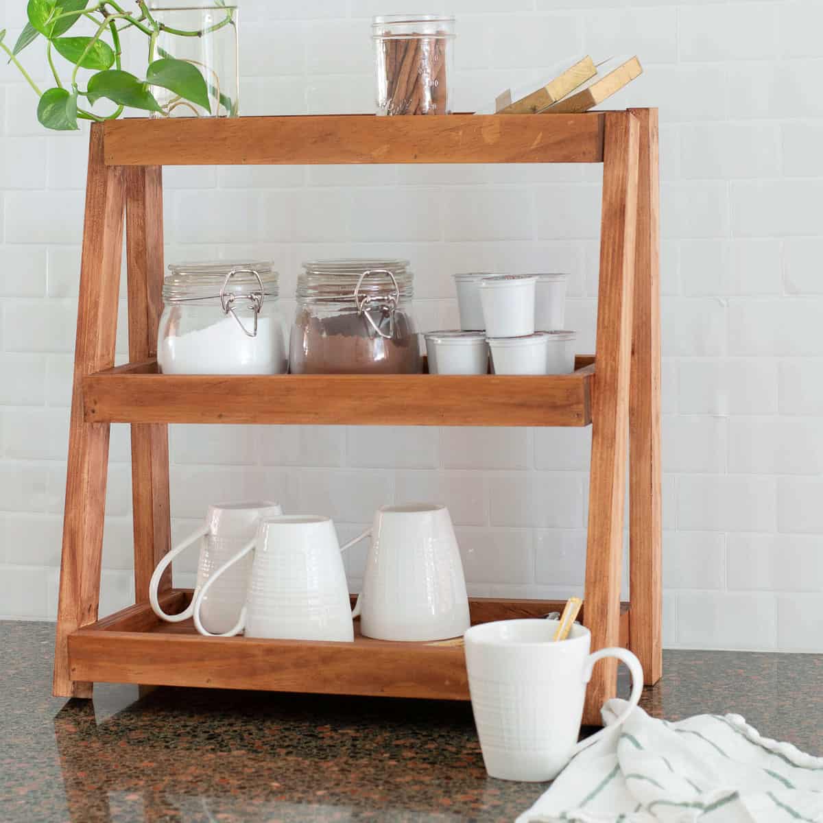 Learn how to build a versatile wooden DIY tiered organizer with this step-by-step tutorial and build plans. It is perfect for the kitchen, bathroom, or office.