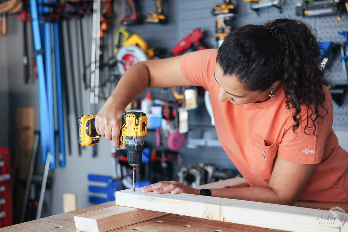 woman adding a fastener into wood