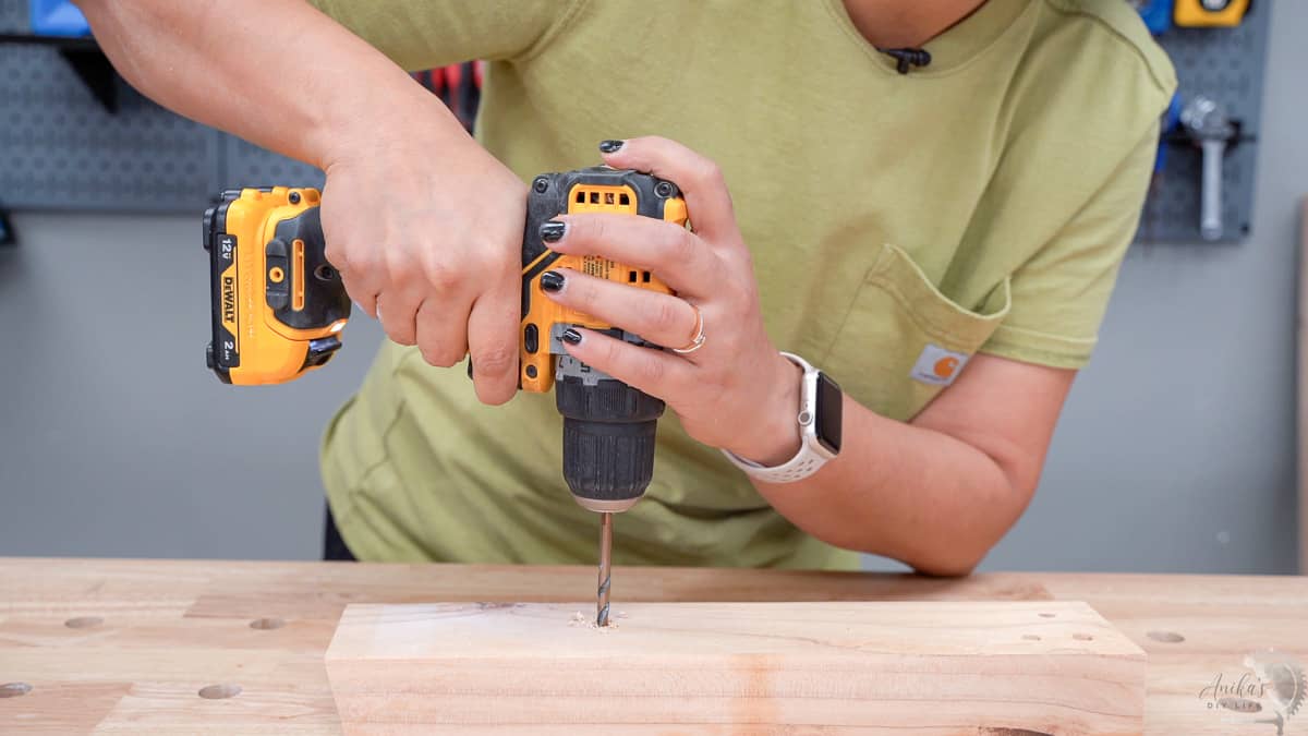 Woman drilling holes in a 2x4