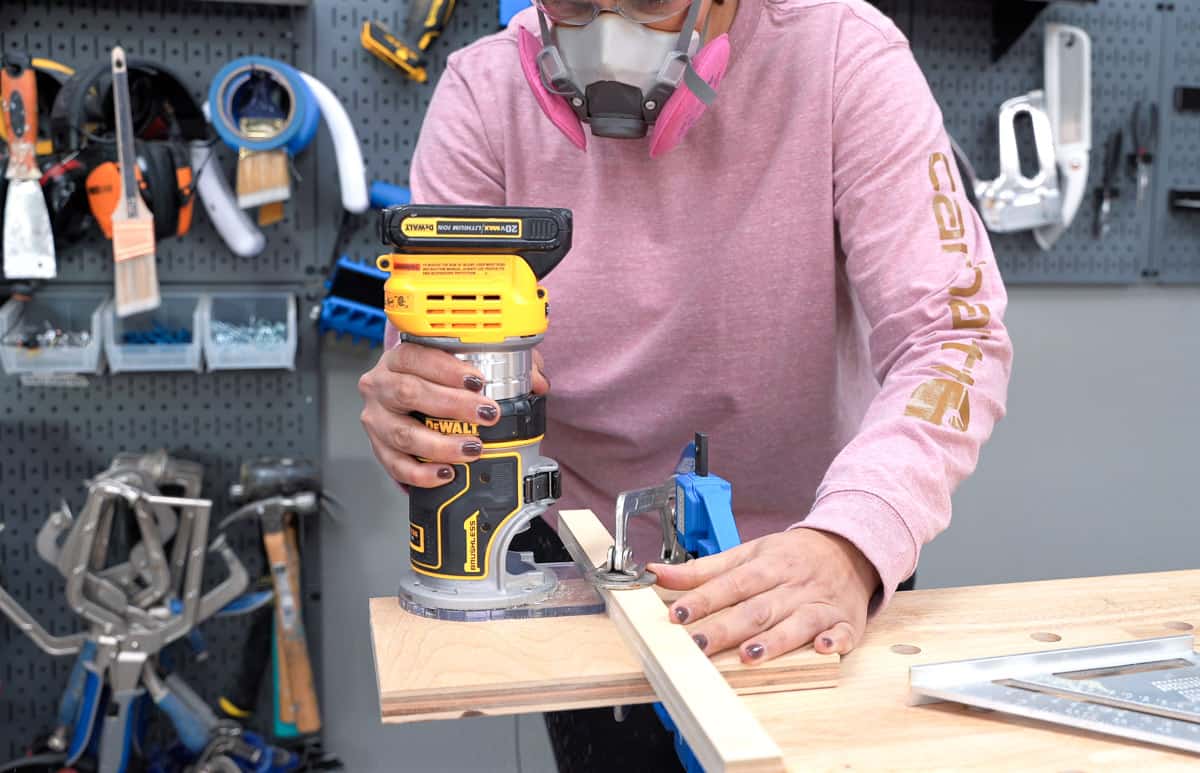 woman running the router to make a groove in plywood