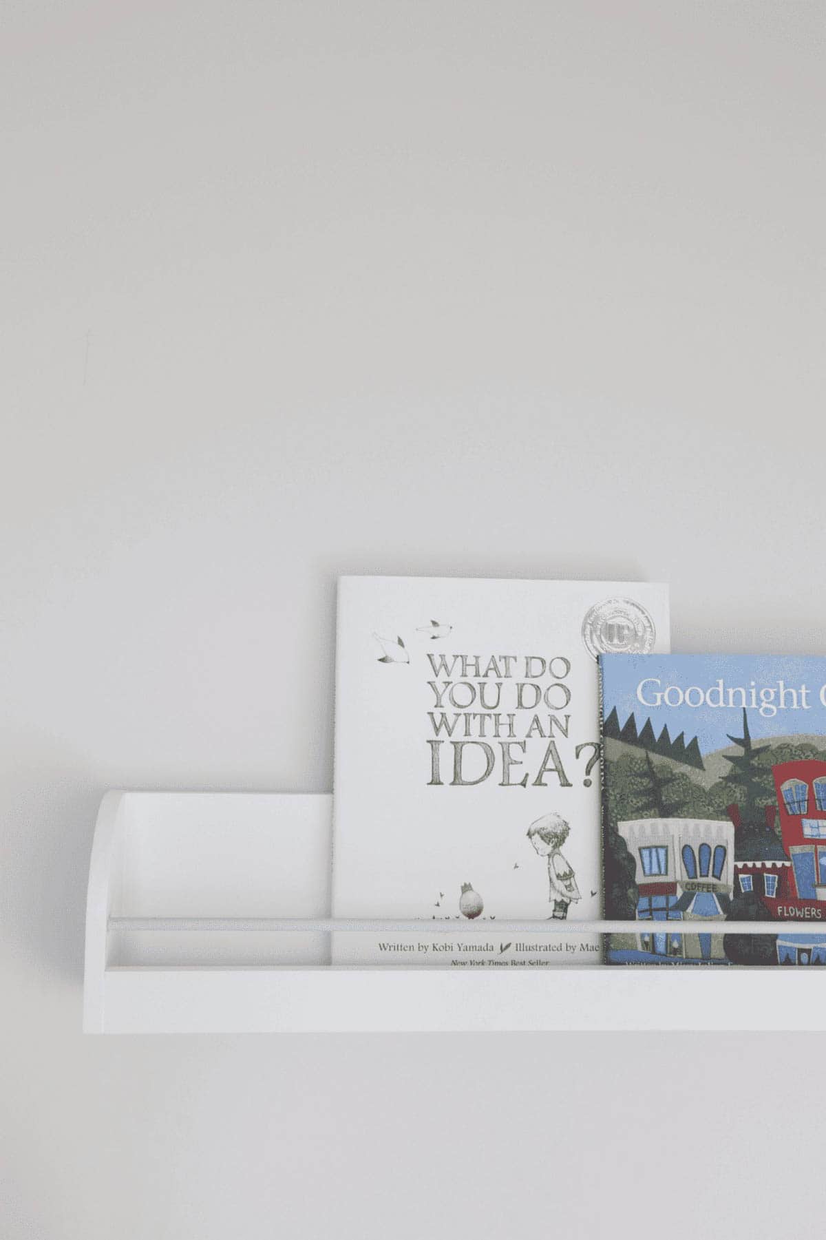 White painted nursery shelf holding children's books