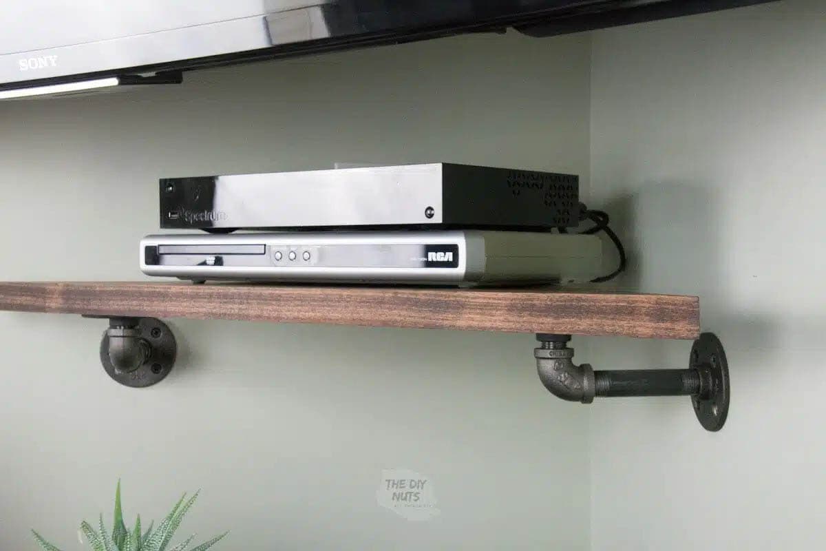 corner wall shelf made with wood and pipe for tv electronics